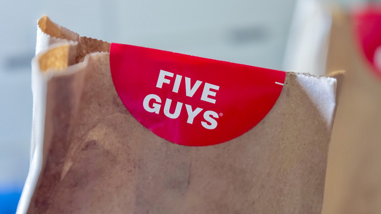 A Five Guys sticker on a brown paper bag