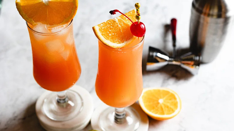 Aerial view of two Hurricane cocktails with cherry garnish and shaker in background
