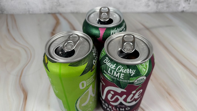 Top-down of three open Nixie cans on table