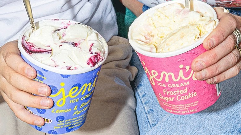 Hands of two people holding pints of Jeni's Splendid Ice Creams.