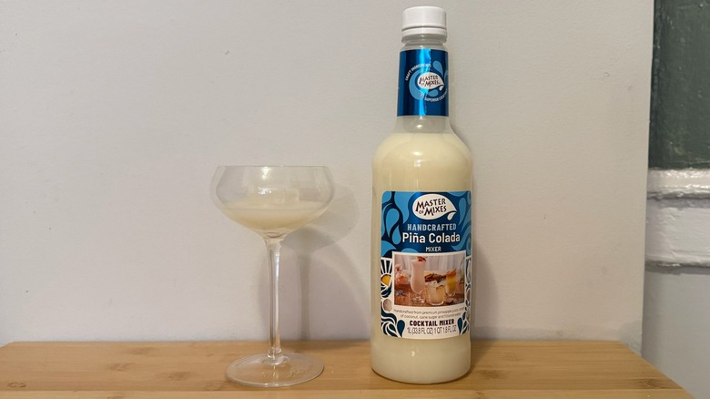 Master of Mixes piña colada bottle with a glass filled next to it