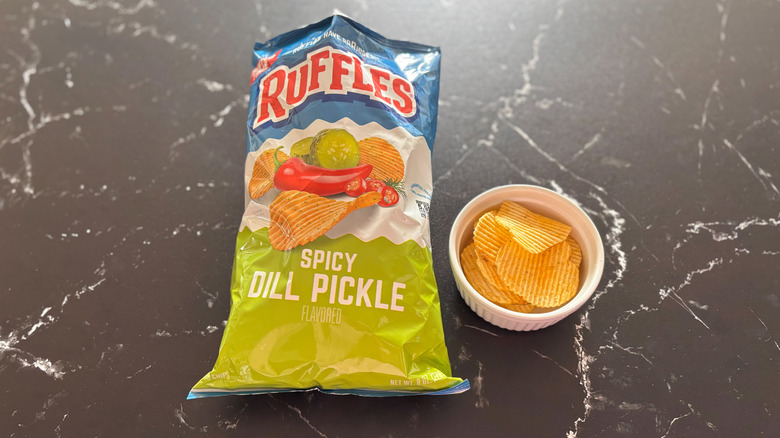 Ruffles spicy dill pickle chip bag next to bowl of chips