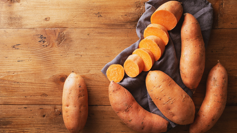 Sweet potatoes on wood surface with towel