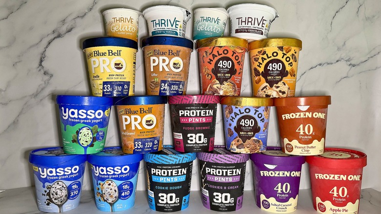 Pyramid of protein ice cream containers on marble surface