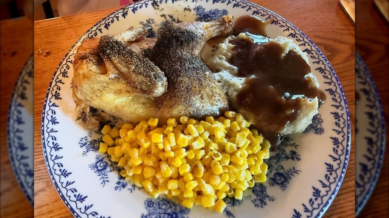 Plate of chicken, corn and mashed potato topped with gravy