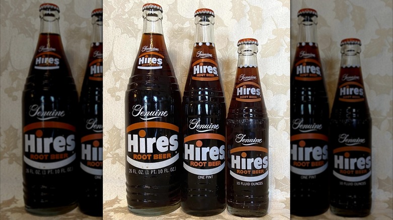 Mirrored image of three glass bottles of Hires Root Beer