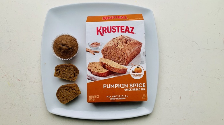 Box of Krusteaz Pumpkin Spice Quick Bread Mix on a plate with baked cupcakes