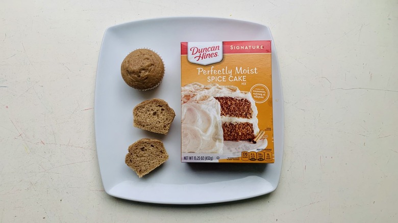 Box of Duncan Hines Spice Cake mix on a plate with baked cupcakes