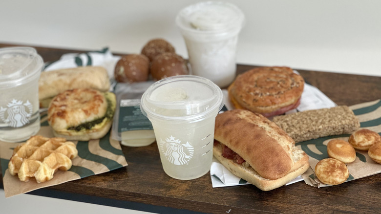 Angled image of assorted Starbucks items on wooden console table
