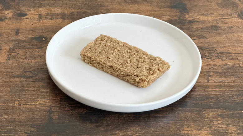 Wooden table with white plate with oat bar