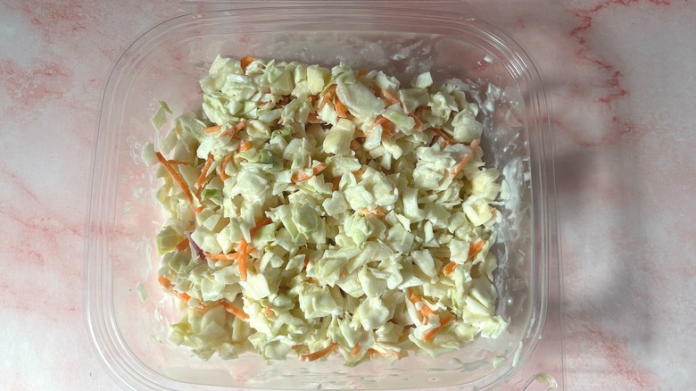 Signature Select coleslaw container on pink surface