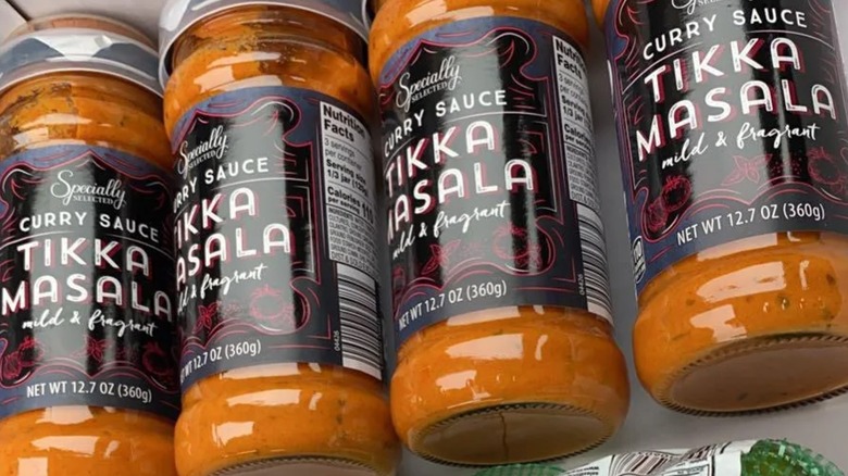 Four jars of Specially Selected tikka masala curry sauce lying side by side