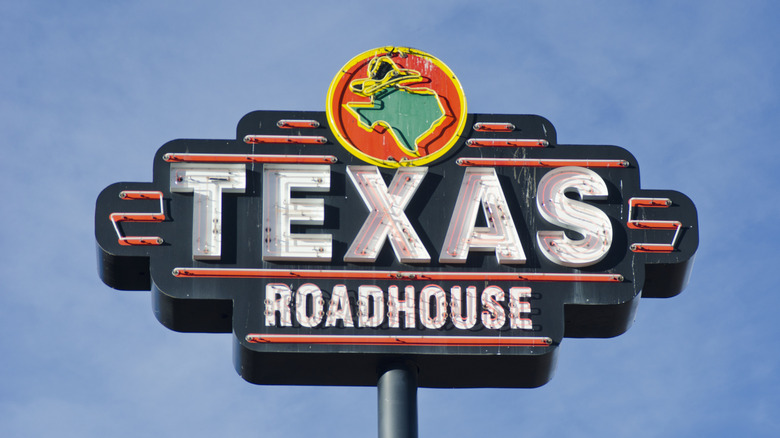 Large Texas Roadhouse sign against blue sky