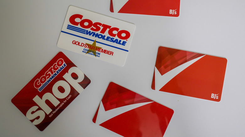 BJ's and Costco membership cards scattered on a white table.