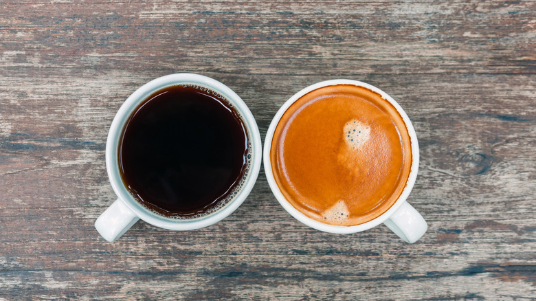 A top view of an espresso drink and a cup of drip coffee in white cups on a wood table