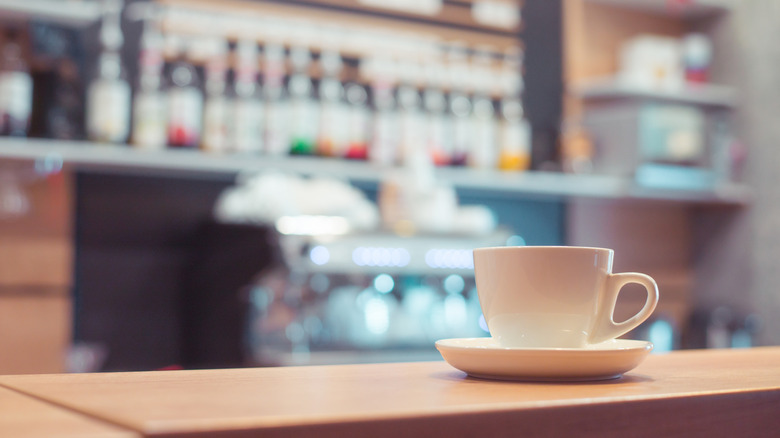 A white coffee cup left on the counter at a coffee shop
