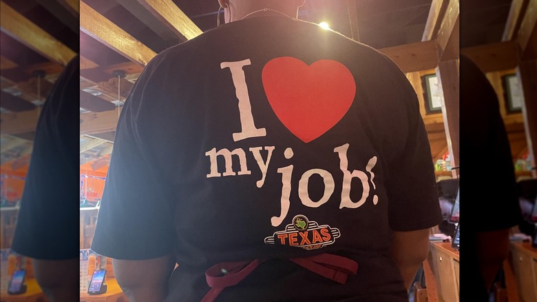 Mirrored image of a server's back, wearing the 'i love my job' shirt
