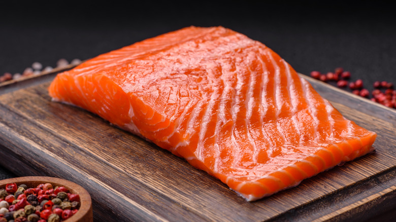 Raw salmon filet on wooden cutting board