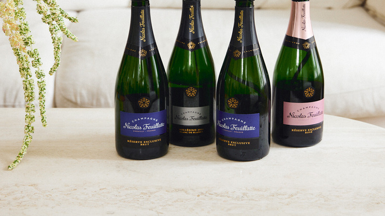line up with four champagne bottles