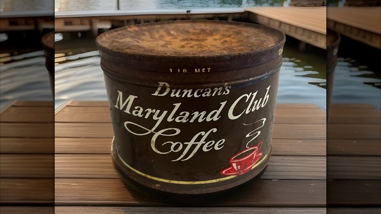 Old Maryland Club Coffee can against scenic lake background