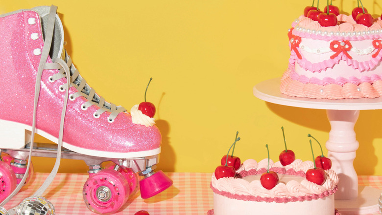 Pink roller skate next to pink cakes on table