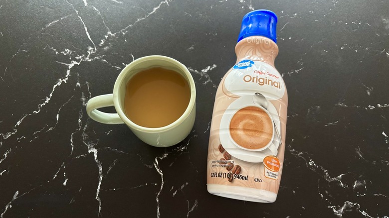 Cup of coffee next to Great Value original coffee creamer
