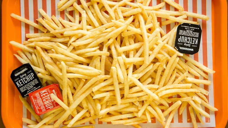 French fries on a Whataburger tray, surrounded by dipping sauces