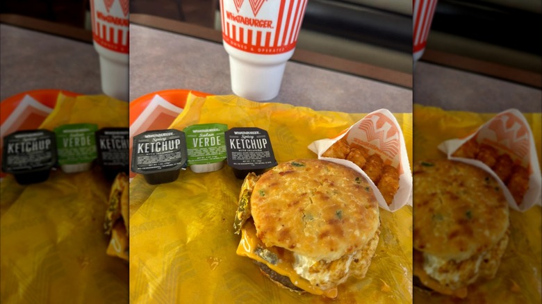 Jalapeño cheddar biscuit with sausage, cheese, and egg, with a side of hash browns and three dipping sauces