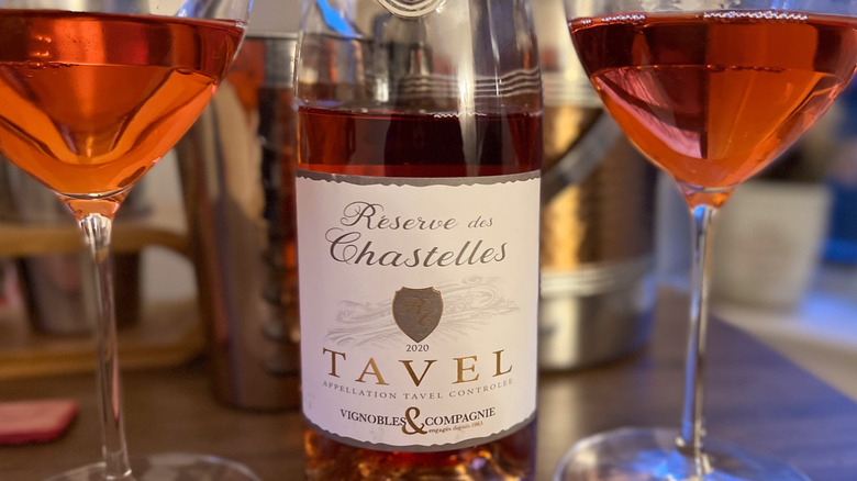 A bottle of rosé wine from Tavel, between two glasses of the wine