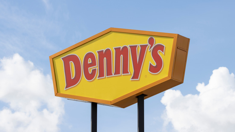 Denny's sign against blue cloudy sky