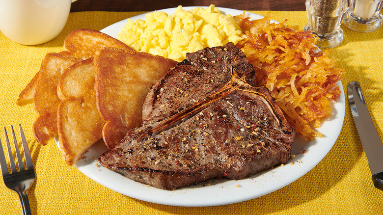 Denny's T-Bone steak and eggs on white plate and yellow placemat
