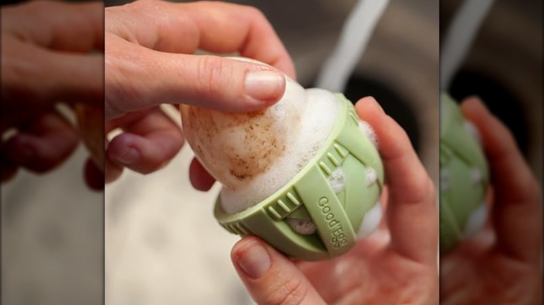 The Original Egg Brush being used to clean an egg with soapy water