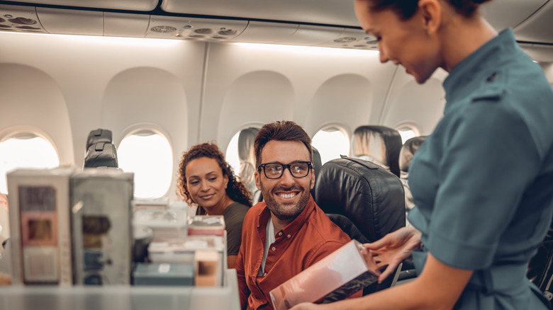 A flight attendant serving a passenger