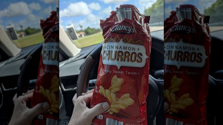 Person in car holding a bag of Clancy's Cinnamon Churros
