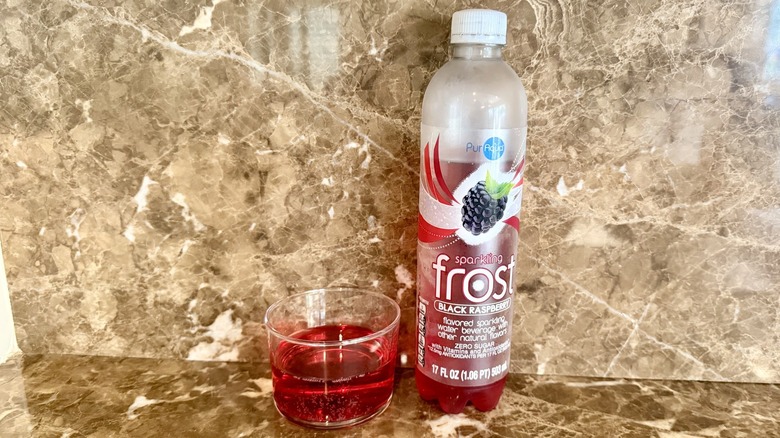 Black Raspberry Frost Water bottle next to a little poured in a glass