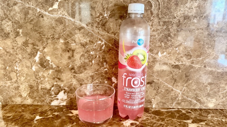 Strawberry Kiwi Frost Water bottle next to a little poured in a glass