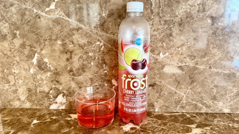 Cherry Limeade Frost Water bottle next to a little poured in a glass