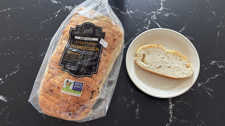 Aldi Specially Selected everything sourdough bread sliced in a bag next to slice of the bread on a plate
