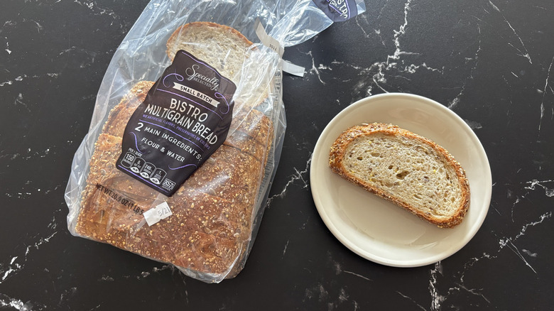 Aldi Specially Selected multigrain bread loaf inn a bag next to slice on plate