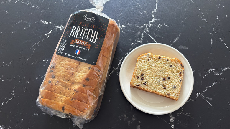 Sliced Aldi Specially Selected chocolate chip brioche loaf next to one slice on a white plate