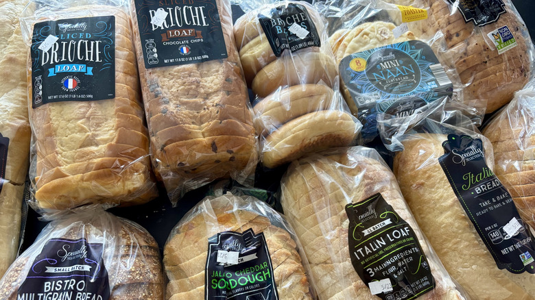Various Aldi Specially Selected breads sliced, bagged, and stacked on countertop