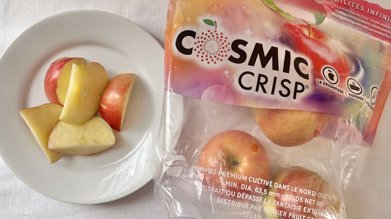 Bag of Cosmic Crisp apples on a table with a plate