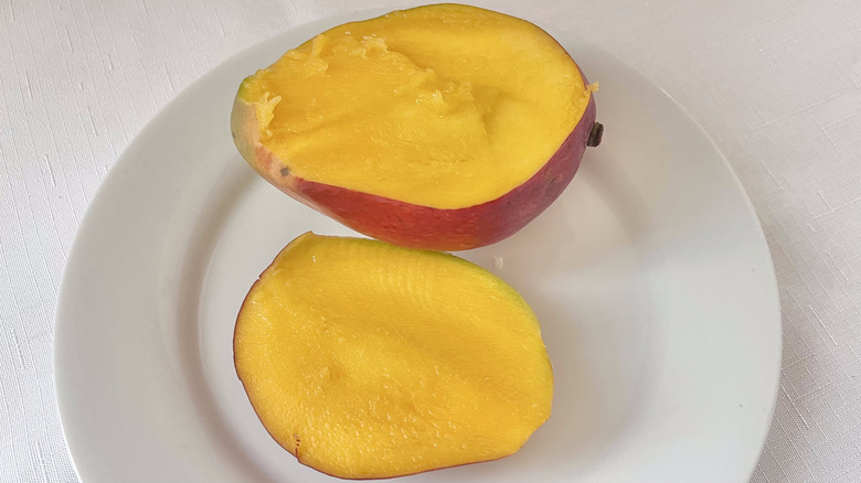 Mango sliced in half on a plate