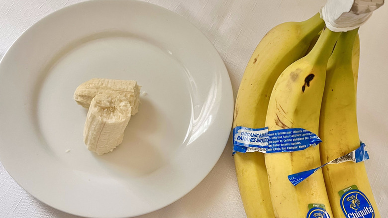 Close up of bananas with a piece on a plate