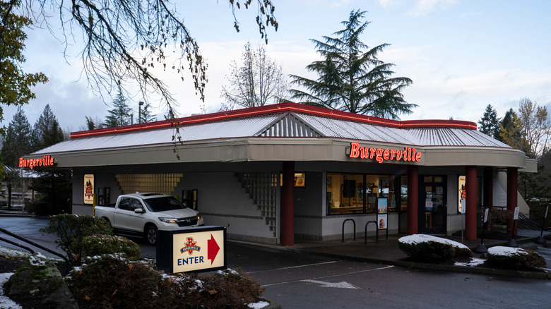 Burgerville exterior with drive-thru in the parking lot and neon sign