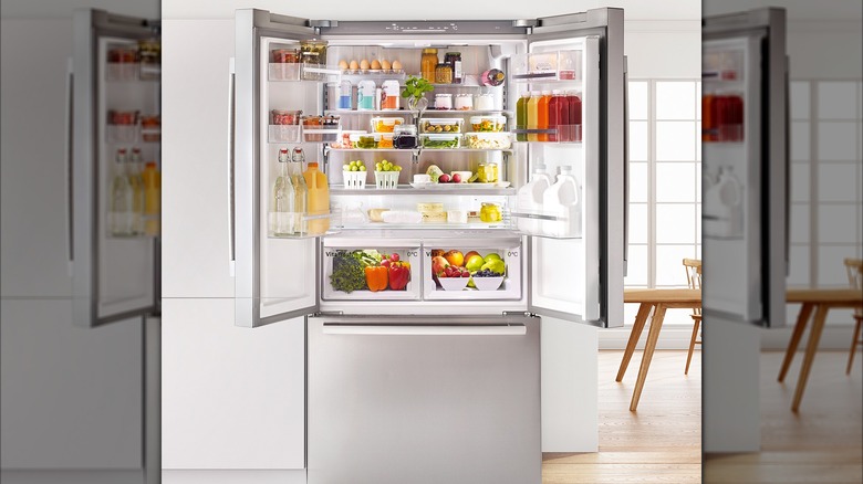 Fridge with lower freezer and two doors open in minamalist kitchen
