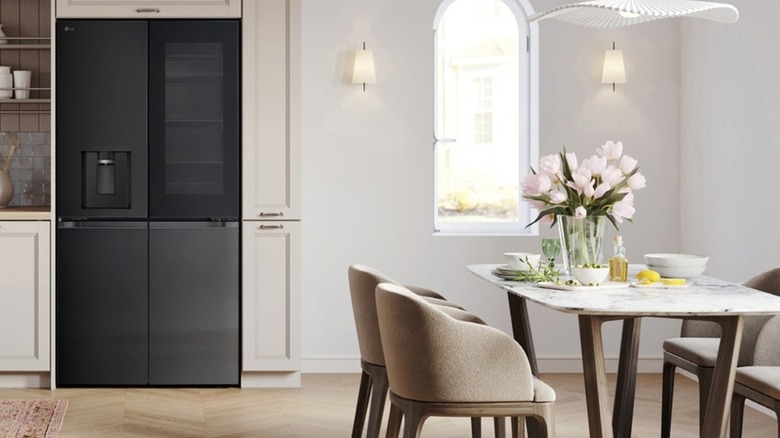 Black LG refrigerator in modern dining room with table and chairs