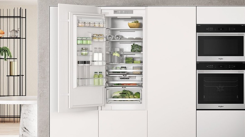 Built-in Whirlpool refrigerator with white cabinets and built-in oven
