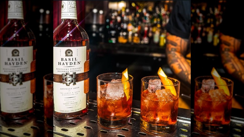 Bottle of Basil Hayden and two old Fashioned cocktails on bar