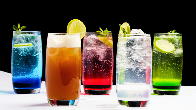Row of differently colored sodas in glasses